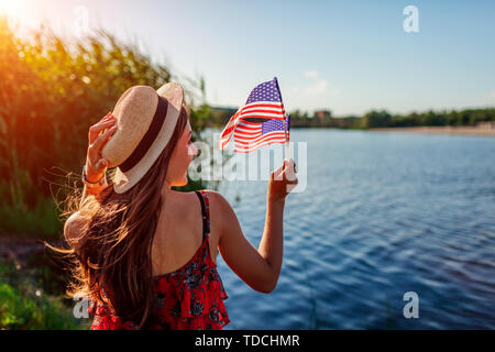 Donna che mantiene bandiera degli Stati Uniti. Per celebrare il Giorno di Indipendenza dell America Foto Stock