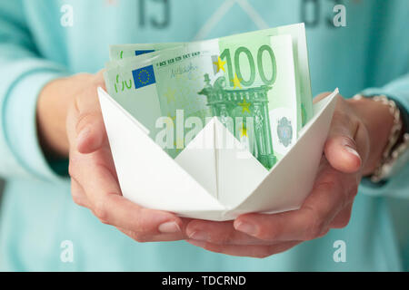 Banconote denaro e barche di carta. Il concetto di business Foto Stock