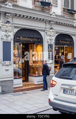 Strasburgo, Francia - 28 OTT 2017: donna adulta in attesa vicino all'entrata di Boulangerie pasticceria tradizionale panetteria con vetrina vintage calligraphy font nel centro di Strasburgo Foto Stock