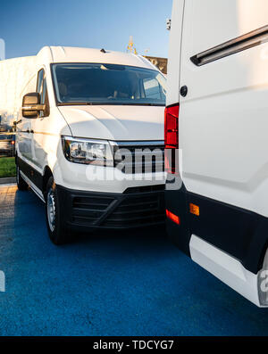 Il carrello industriale e van concessionaria con il bianco furgoni parcheggiati in una fila nel grande spazio anteriore nella parte anteriore dello showroom Foto Stock