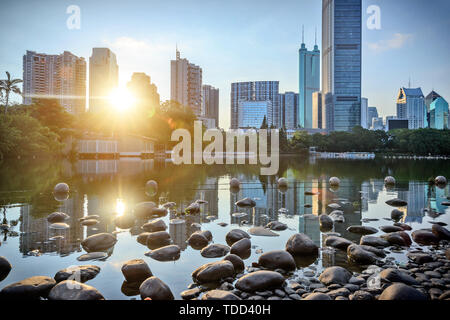 Il lago oltre i grattacieli sotto il tramonto Foto Stock