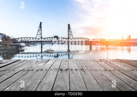 Svuotare il pavimento di legno e ponte sull acqua a sunrise in Portland Foto Stock