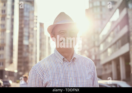 Pensionati ispanica senior l'uomo con il cappello in piedi e sorridente Foto Stock