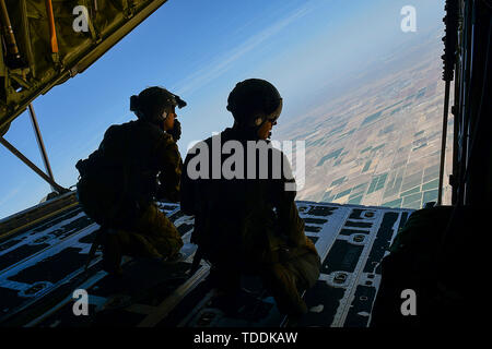 Stati Uniti Avieri dal 79th Rescue Squadron guardare fuori il retro di un HC-130J contro il re II dopo aver eseguito una apparecchiatura airdrop in Arizona meridionale, 9 giugno 2019. La 79th RQS mantiene la lotta contro-stato pronto con HC-130Js e fornisce rapidamente dispiegabile, personale expeditionary forze di recupero per i comandanti di combattente per la definizione di piani di crisi e le operazioni di risposta in tutto il mondo. (U.S. Air Force foto di Airman 1. Classe Kristine legato) Foto Stock