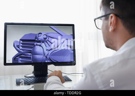 Ingegnere, Costruttore, designer e architetto in bicchieri lavorando su un Personal Computer. Egli la creazione di un nuovo componente nel programma CAD. Freelance lavoro. Foto Stock