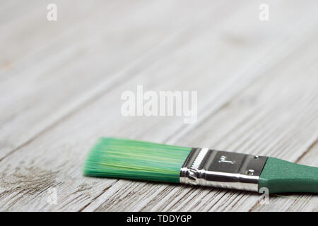 Vernice verde a pennello sul grigio Sfondo di legno Foto Stock