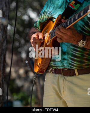 Close-up di mano suonare una chitarra elettrica a un concerto all'aperto Foto Stock