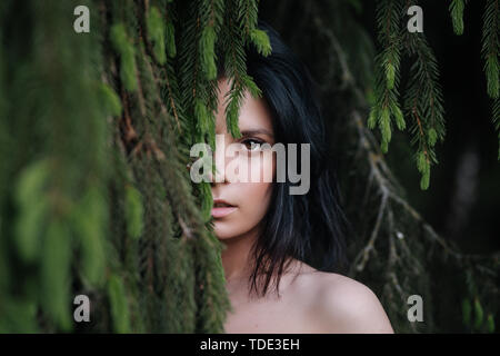 Close-up ritratto di attraente giovane donna nella foresta metà faccia . bella ragazza nel bosco Foto Stock