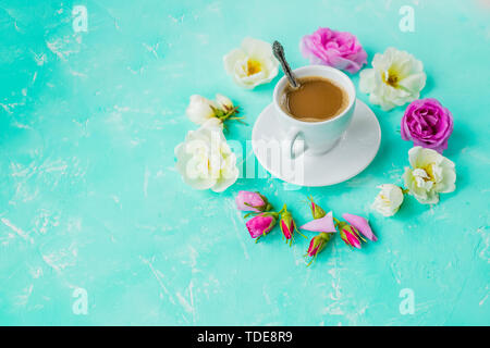 La tazza di caffè e bouquet di rose fiori su sfondo color pastello. Vista dall'alto, il surriscaldamento. Appartamento in stile laici composizione, cornice rotonda ghirlanda fatta di rose beige Foto Stock