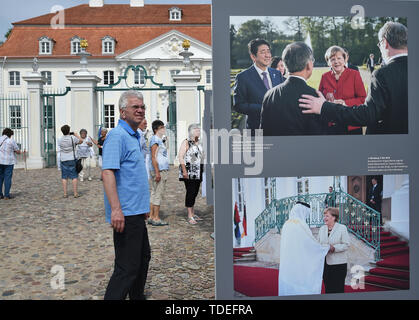 15 giugno 2019, Brandeburgo, Gransee/OT Meseberg: Visitatori guarda le foto del protocollo appuntamenti di fronte a Meseberg Castello. Il castello è la guest house del governo federale. Il giorno della porta aperta, selezionate le camere al piano terra così come il parco all'Huwenowsee può essere visitato. Foto: Bernd Settnik/dpa-Zentralbild/dpa Foto Stock