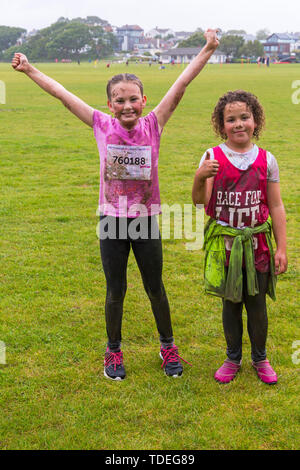 Baiter Park, Poole, Dorset, Regno Unito. Il 15 giugno 2019. Freddo umido giorno di gara per la vita piuttosto fangosa bambini dove i bambini possono unirsi nella lotta per sconfiggere il cancro e raccogliere fondi a favore della ricerca sul cancro del Regno Unito. I bambini oltre i 1,2 m di altezza e fino a 12 anni accompagnati da un adulto, negoziare gli ostacoli durante tutto il corso che è fino a 5 km e divertirsi sempre coperto di fango. Mudders Daisy e Gracie (autorizzazione ricevuta). Credito: Carolyn Jenkins/Alamy Live News Foto Stock