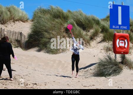 Campanatura, East Sussex, Regno Unito. Il 15 giugno, 2019. Una bella e soleggiata inizio di weekend nella campanatura, East Sussex come la gente arriva al Camber Sands Beach per godere del clima caldo. Amici giocare bat e la sfera sulla spiaggia. Credito: Paolo Lawrenson 2019, Photo credit: Paolo Lawrenson/Alamy Live News Foto Stock