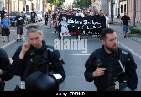 Roßlau, Germania. Il 15 giugno, 2019. 15 giugno 2019, Sassonia-Anhalt, Dessau-Roßlau: i partecipanti di una dimostrazione a piedi attraverso il quartiere Roßlau con un banner con la scritta 'pene più severe per gli stranieri criminali". Sul Whitsunday una ragazza ha detto di essere stato oggetto di abusi da parte di una persona sospetta dal Niger. Circa 100 persone hanno partecipato alla riunione. Foto: Sebastian Willnow/dpa-Zentralbild/ZB Credito: dpa picture alliance/Alamy Live News Foto Stock