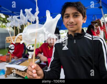 Toronto, Canada. Il 15 giugno, 2019. Un ragazzo pone per le foto con uno zucchero-figura soffiata da se stesso durante la Cina Turismo e cultura settimana a Toronto, in Canada, il 15 giugno 2019. La Cina il turismo e la Settimana della Cultura ha dato dei calci a fuori a Toronto sabato alla vetrina della Cina di paesaggi, cultura e cibo, che attira centinaia di visitatori. Credito: Zou Zheng/Xinhua/Alamy Live News Foto Stock