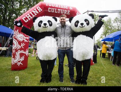 Toronto, Canada. Il 15 giugno, 2019. Un visitatore (C) pone per le foto con costume panda giganti durante la Cina Turismo e cultura settimana a Toronto, in Canada, il 15 giugno 2019. La Cina il turismo e la Settimana della Cultura ha dato dei calci a fuori a Toronto sabato alla vetrina della Cina di paesaggi, cultura e cibo, che attira centinaia di visitatori. Credito: Zou Zheng/Xinhua/Alamy Live News Foto Stock