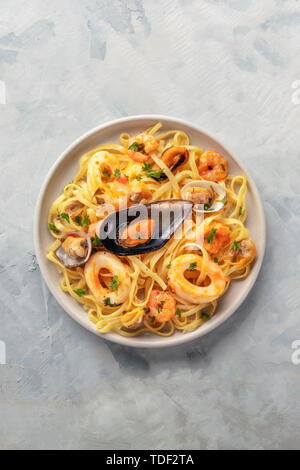 Piatti di pasta. Un overhead foto di un piatto di tagliolini con cozze, gamberi, vongole e calamari, con copyspace Foto Stock