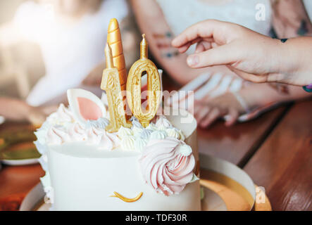 I bambini con le mani in mano bambine raggiungere per la torta. Grande bella torta unicorn sugli anni compleanno della principessina sulla tavola festiva Foto Stock