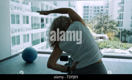 Donna anziana rende squattings in palestra. Donna anziana donna Senior fa un sport esercizi in palestra. Foto Stock