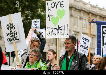 Gli attivisti tenere cartelloni durante la giustizia per Grenfell solidarietà rally contro la mancanza di azione da parte del governo a seguito della torre Grenfell fire, in rientro famiglie colpite, ritardi nell'inchiesta pubblica, blocchi a torre ancora coperto nel rivestimento infiammabili, la contaminazione del suolo e delle prestazioni del Royal Borough di Kensington e Chelsea. Il 14 giugno 2017, appena prima di 1:00 un incendio scoppiato nella cucina del quarto piano a 24 piani torre residenziale blocco nel Nord di Kensington, a ovest di Londra, che è costato la vita a 72 persone. Più di 70 altri sono stati feriti e 223 peopl Foto Stock