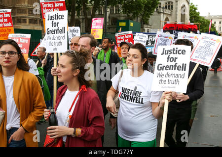 Gli attivisti tenere cartelloni durante la giustizia per Grenfell solidarietà rally contro la mancanza di azione da parte del governo a seguito della torre Grenfell fire, in rientro famiglie colpite, ritardi nell'inchiesta pubblica, blocchi a torre ancora coperto nel rivestimento infiammabili, la contaminazione del suolo e delle prestazioni del Royal Borough di Kensington e Chelsea. Il 14 giugno 2017, appena prima di 1:00 un incendio scoppiato nella cucina del quarto piano a 24 piani torre residenziale blocco nel Nord di Kensington, a ovest di Londra, che è costato la vita a 72 persone. Più di 70 altri sono stati feriti e 223 peopl Foto Stock