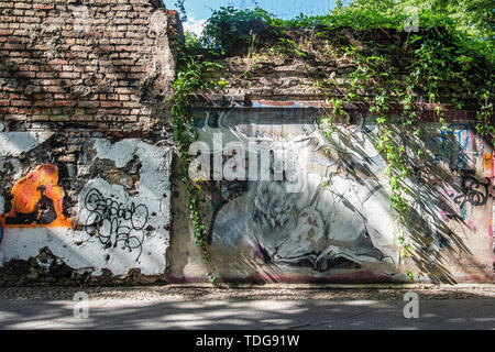 Graffiti-Cimitero coperto con il muro di mattoni a vista e arte di strada in Baruther strasse, Kreuzberg-Berlin Foto Stock