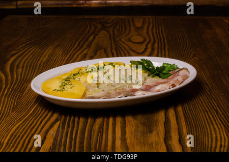 Pesce salato con patate bollite e Cipolline borretane Foto Stock