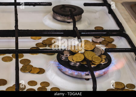 Blue Flames di gas naturale di masterizzazione da un fornello a gas su uno sfondo di monete. Foto Stock