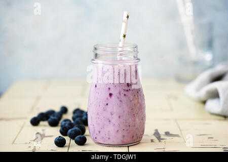 Frullato di mirtilli in bottiglia con cannuccia. Fresche deliziose berry smoothie. Vegano dieta vegetariana concetto, pulire mangiare e perdita di peso Foto Stock