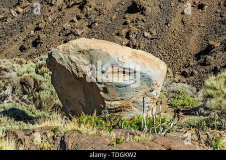 Via sassosa in altopiano circondato da montagne e campi di lava intorno al vulcano Teide. Un enorme fiume di lava roccia alla giornata di sole. . Tracciamento rocciose strada in montagna a secco Foto Stock