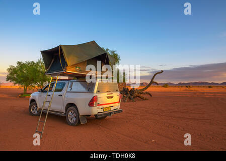 Tenda che si trova sul tetto di un pickup 4x4 auto in un deserto camp, Namibia Foto Stock