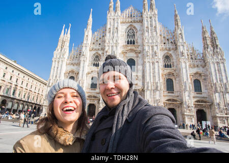 Viaggi, Italia e vacanze concetto - Happy turisti prendendo un autoritratto di fronte la Cattedrale del Duomo di Milano Foto Stock