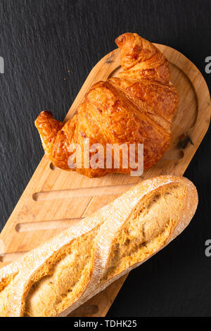 Concetto di cibo croissant francesi sul nero ardesia scheda con spazio di copia Foto Stock