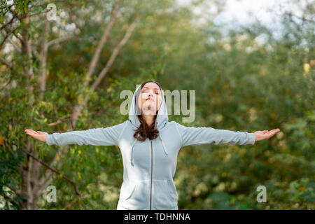 Bella donna facendo respirazione profonda esercita in un parco. Foto Stock