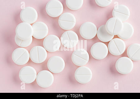 Medicinali compresse rotonde su uno sfondo rosa Foto Stock