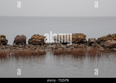 In rovina di recinzione in pietra circondato da acqua di mare Foto Stock