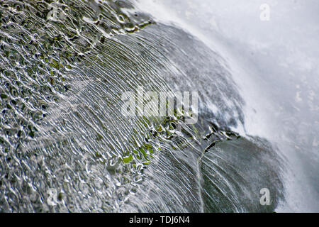 Un sottile strato di ghiaccio sul flusso in Tianchi Scenic Area in Tianshan, Xinjiang in inverno delinea la forma del flusso d'acqua. Foto Stock