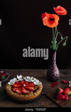 Crostata di fragole con semi di papavero fiori su un tavolo di legno Foto Stock