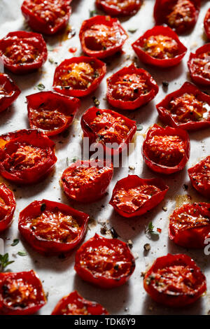 Arrosto di pomodori ciliegini, cosparsi di foglie di timo, sale marino e pepe nero pestato. Foto Stock