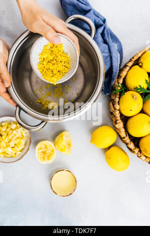 Donna fare marmellata di limone in una pentola Foto Stock