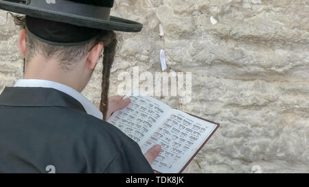Close up di un uomo ebraico adorare con un libro di preghiera al Muro Occidentale di Gerusalemme, Israele Foto Stock