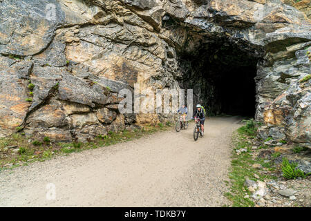Matura in bicicletta in corrispondenza di uno dei tunnel del bollitore Valley Railway (KVR) una ferrovia abbandonata convertito ad un escursionismo/mountain bike trail. Foto Stock