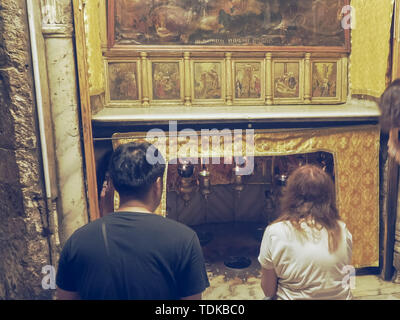 Betlemme, Palestina- SETTEMBRE, 22, 2016: tre whorshipers inginocchiare presso la stella nella chiesa della Natività di Betlemme Foto Stock