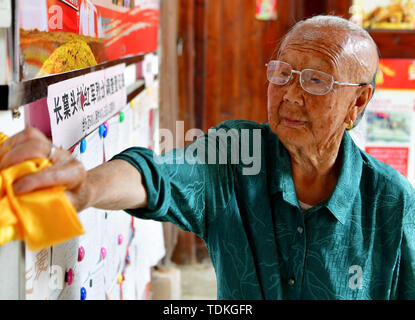 Changting, la Cina della provincia del Fujian. 16 Giugno, 2019. Tu Chengxiu, moglie di 91-anno-vecchi pensionati cadre Zhong Yilong, pulisce la scheda dello schermo a casa sua nel villaggio Changketou di Nanshan cittadina nella contea di Changting, a sud-est della Cina di provincia del Fujian, 16 giugno 2019. Dal 1953, Zhong Yilong raccolti i nomi dei martiri che hanno partecipato in giro dal 1928 al 1934. Egli ha anche istituito una mostra per quanto riguarda l'esercito rosso presso la sua casa ancestrale di parecchi anni fa passare la storia verso il basso. Credito: Wei Peiquan/Xinhua/Alamy Live News Foto Stock