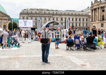 Berlino. Germania, 16 giugno 2019. La folla si riuniranno presso la Bebelplatz davanti a santa Edvige la cattedrale in Unter den Linden per l'annuale gratis Staatsoper für alle Open Air concerto diretto da Daniel Barenboim. L'Orchestra ha eseguito musiche di Johannes Brahms e Felix Mendelssohn Bartholdy su una fase temporanea. La strada è stata chiusa al traffico e i berlinesi e turisti accorsi al concerto area con sedie pieghevoli e ostacola un pic-nic. Credito: Eden Breitz/Alamy Foto Stock