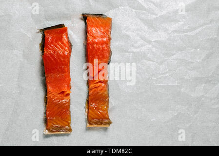Affumicato pesce rosso affettato giace sul bianco carta alimentare Foto Stock