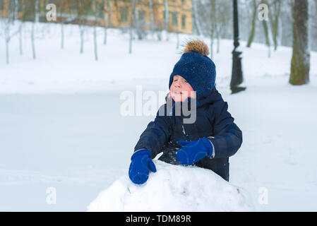 Little Boy è il pianto in inverno nel freddo. Il bambino è triste e stanco. Foto Stock