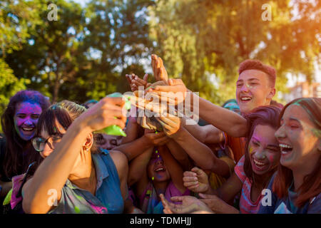 Myrhorod, Ucraina - 16 Giugno 2019: il gruppo di giovani amici di gettare vernici su Indian Holi festival dei colori Foto Stock