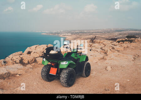 Green Atv offroad il mare e il cielo dello sfondo. Cipro Ayia Napa. moto quad per affitto per l'intrattenimento dei turisti. La guida off-road nel deserto Foto Stock