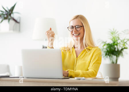 Raggiungere il successo. Donna matura la lettura di buone notizie su Laptop Foto Stock