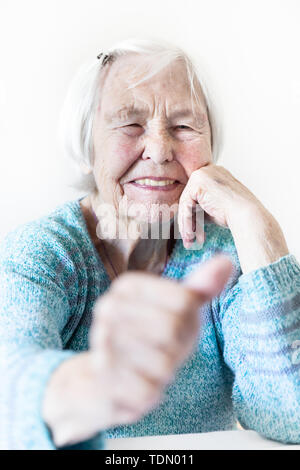 Happy 96 anni donna anziana dando un pollice in alto e guardando la fotocamera. Foto Stock